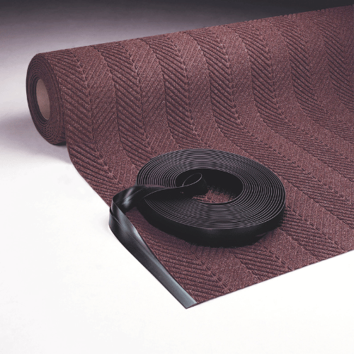 Roll goods carpet edge with flexible black vinyl nosing trim for a clean professional finish