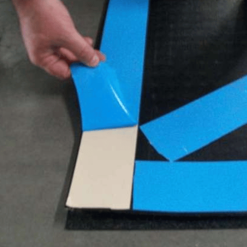 Industrial-strength double-sided tape with silicone-coated blue liner for secure mat installation